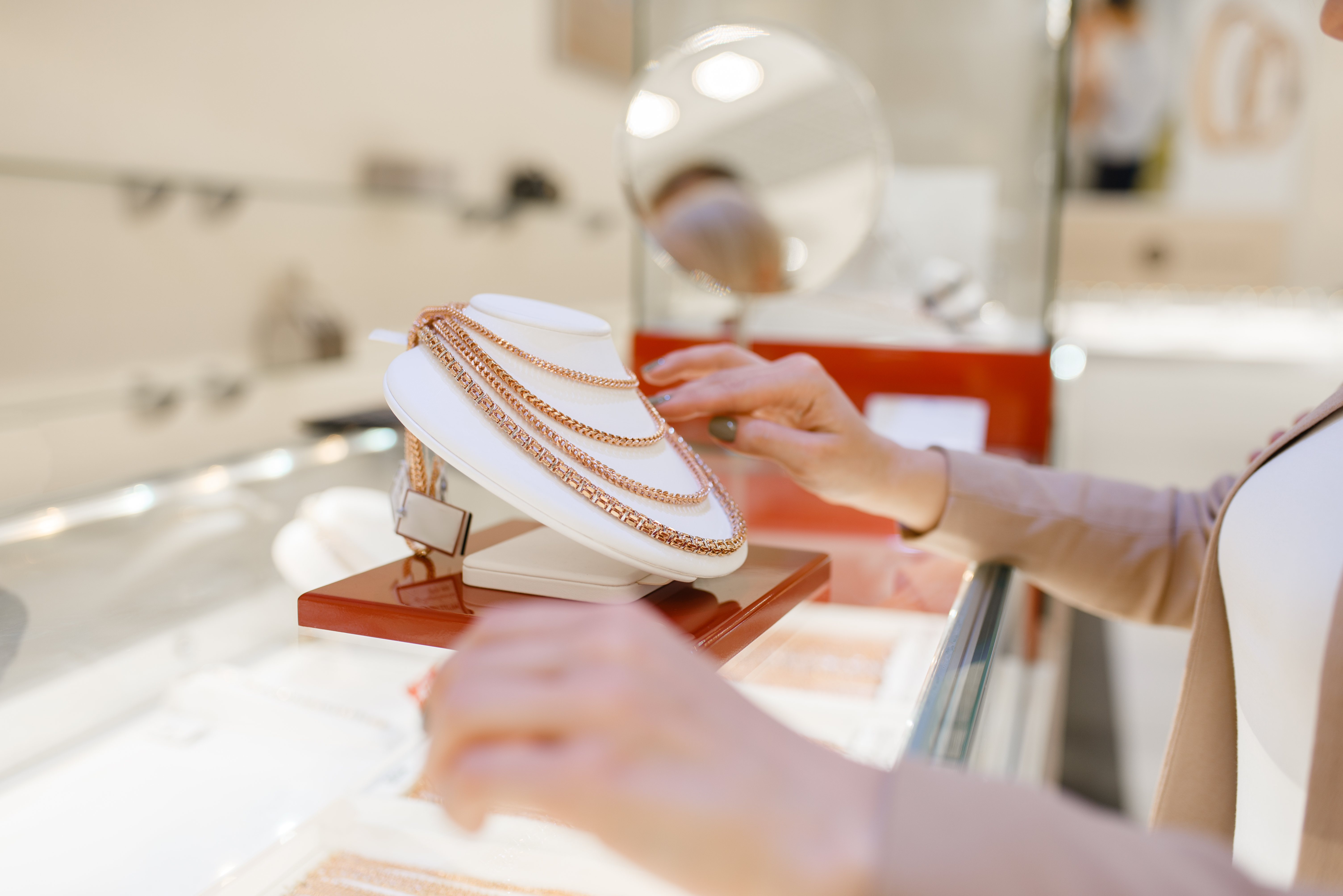 woman choosing golden necklace showcase jewelry store female person buying gold decoration jewellery shop